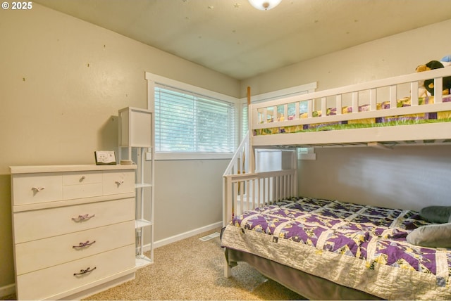 bedroom with visible vents, light carpet, and baseboards