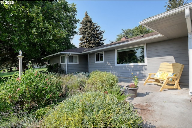 view of front of home featuring a chimney and a patio area