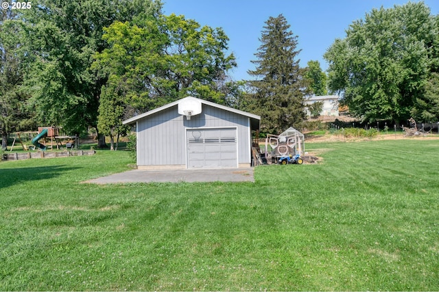 view of yard featuring a garage, an outbuilding, and a playground