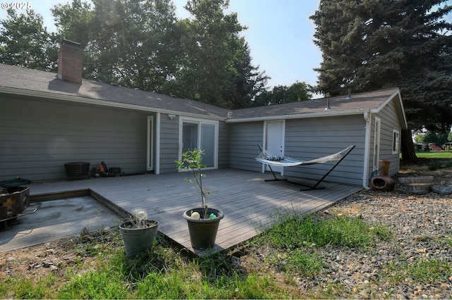 rear view of property featuring a wooden deck and a chimney