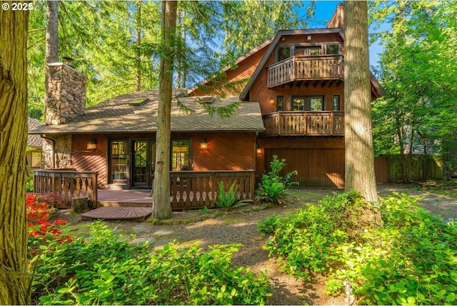 65257 E Sandy River Ln, Rhododendron, OR 97049 - rear view of property featuring a chimney, a balcony, roof with shingles, and a wooden deck