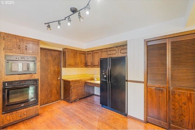 65257 E Sandy River Ln, Rhododendron, OR 97049 - kitchen with black refrigerator with ice dispenser, brown cabinetry, light wood-type flooring, light countertops, and wallpapered walls