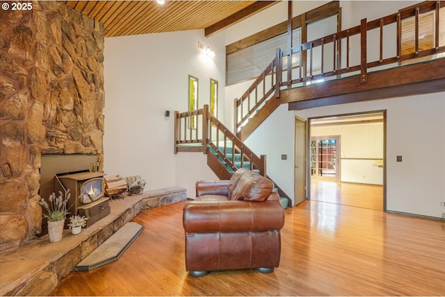 65257 E Sandy River Ln, Rhododendron, OR 97049 - living area featuring wood finished floors, stairs, wooden ceiling, a wood stove, and high vaulted ceiling