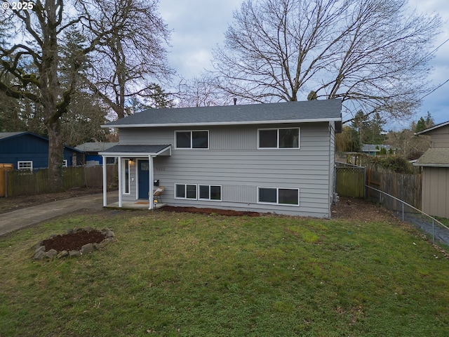 view of front of home with a front yard, fence, and driveway