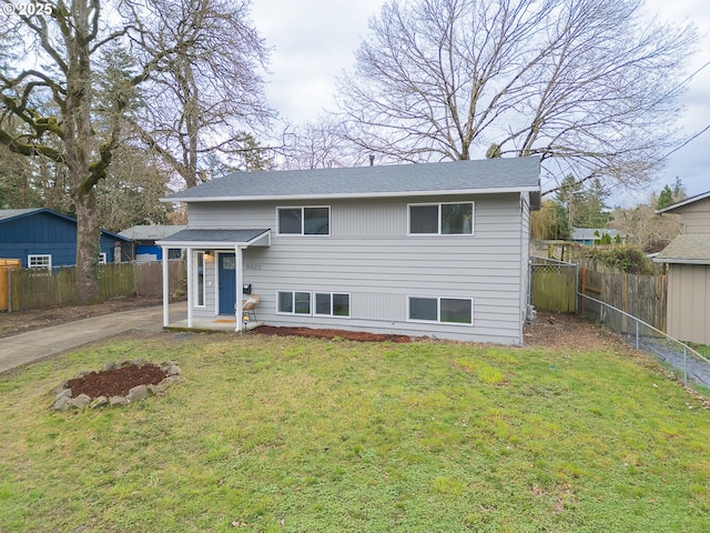 view of front of home with driveway, a front lawn, and fence