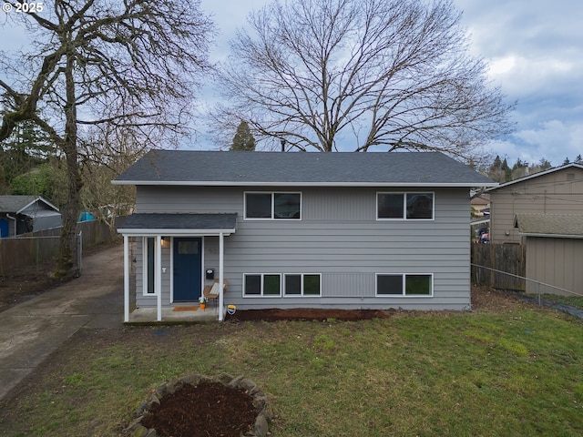 back of property featuring a yard and fence