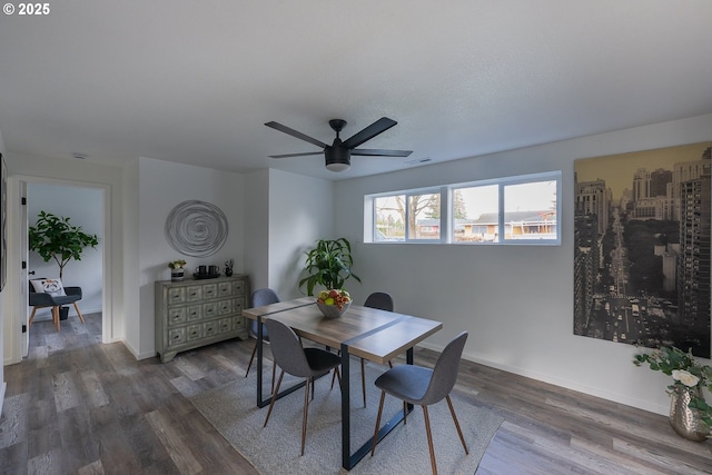 dining room with visible vents, wood finished floors, a ceiling fan, and baseboards