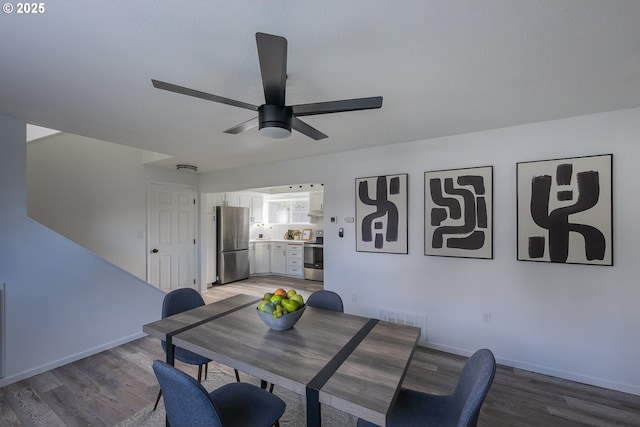 dining space featuring ceiling fan, light wood finished floors, visible vents, and baseboards