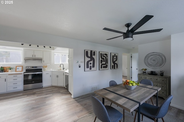 dining space with a ceiling fan, visible vents, and light wood-style flooring