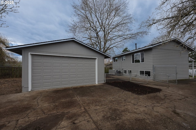 view of home's exterior with a garage, an outbuilding, and fence