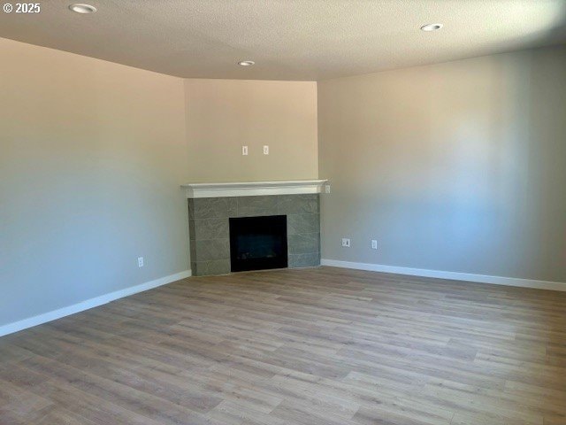 1747 N Millican Creek St, Lafayette, OR 97127 - unfurnished living room with recessed lighting, wood finished floors, a tile fireplace, baseboards, and a textured ceiling
