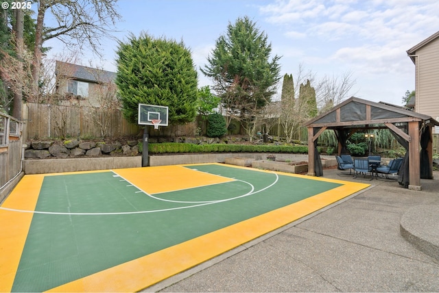 view of basketball court with basketball hoop, fence, and a gazebo