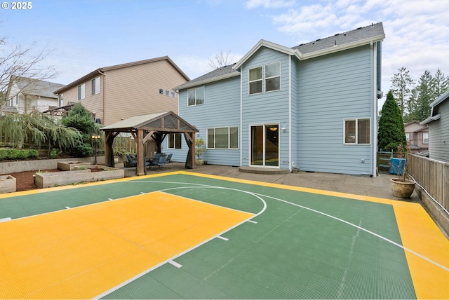 view of basketball court with basketball hoop, fence, and a gazebo