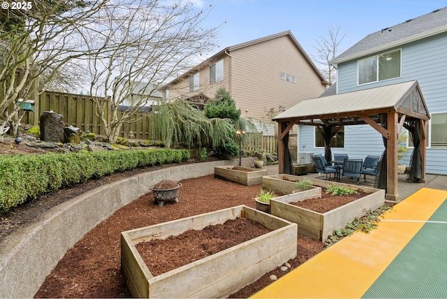 view of home's community with a garden, fence, and a gazebo