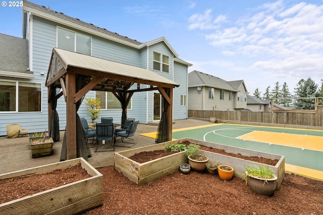 view of basketball court with a residential view, fence, and a gazebo