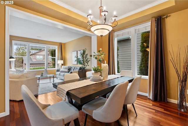 dining area featuring baseboards, a chandelier, wood finished floors, and ornamental molding