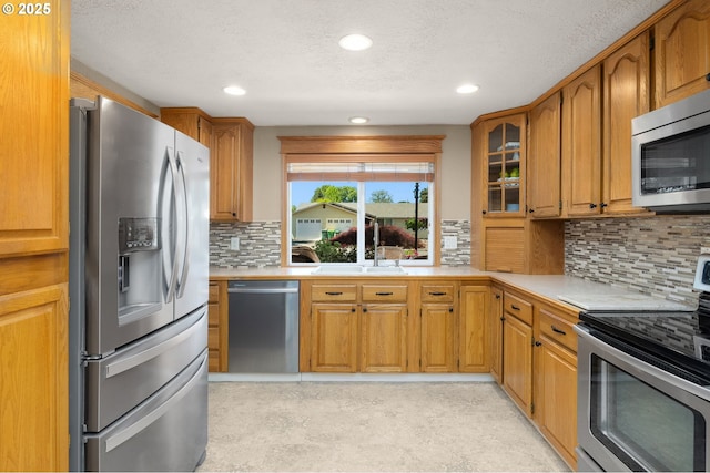 1615 Kingwood St, Forest Grove, OR 97116 - kitchen featuring appliances with stainless steel finishes, light countertops, a sink, brown cabinets, and recessed lighting