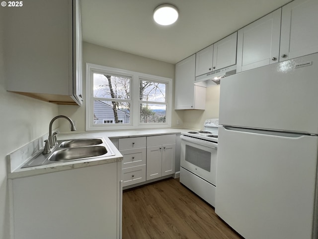 kitchen featuring dark wood-style floors, white cabinets, a sink, white appliances, and under cabinet range hood