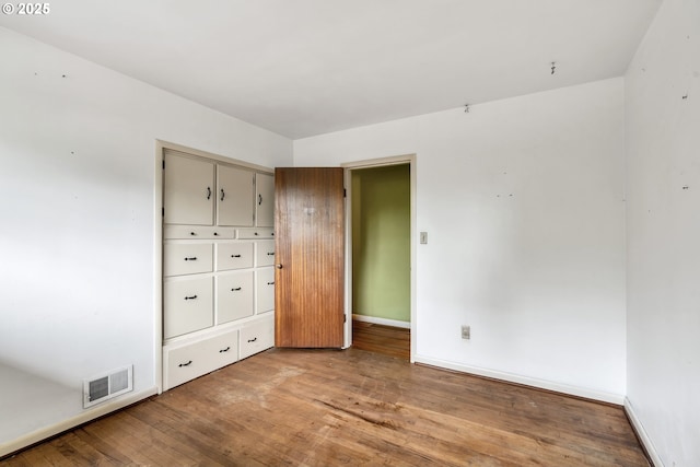 unfurnished bedroom featuring baseboards, visible vents, and light wood-style floors