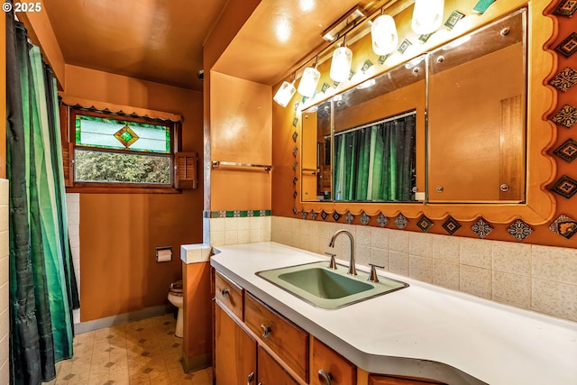 full bathroom featuring toilet, vanity, baseboards, and tile patterned floors