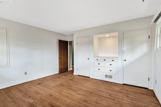 unfurnished bedroom with light wood-style floors, baseboards, and visible vents