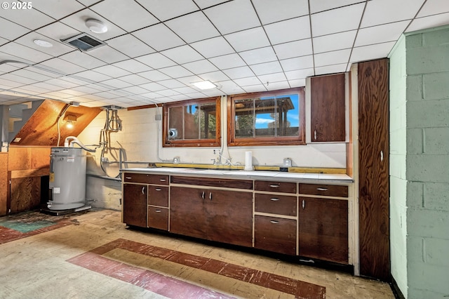 kitchen featuring water heater, light countertops, and dark brown cabinetry