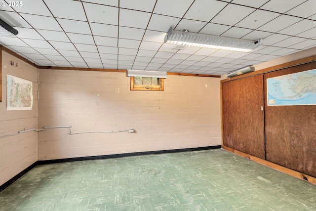 basement featuring concrete block wall and tile patterned floors