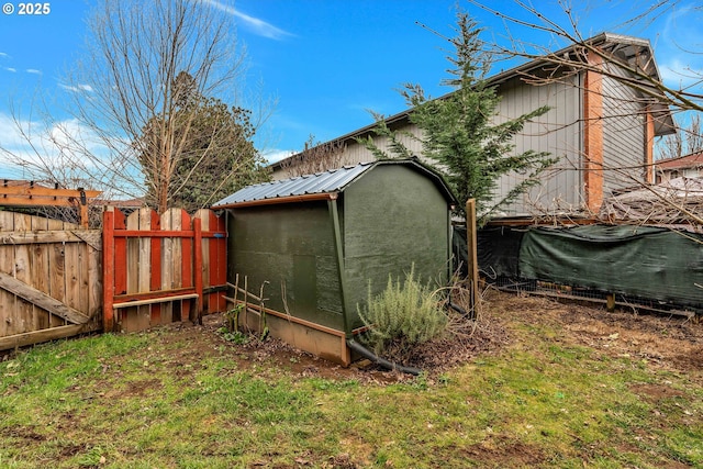 view of yard with an outbuilding, a storage shed, and fence