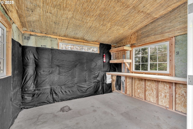 interior space featuring concrete floors and vaulted ceiling