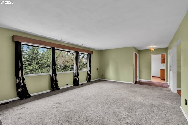 spare room featuring carpet and baseboards