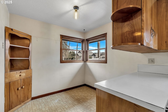 unfurnished dining area with baseboards and a textured ceiling