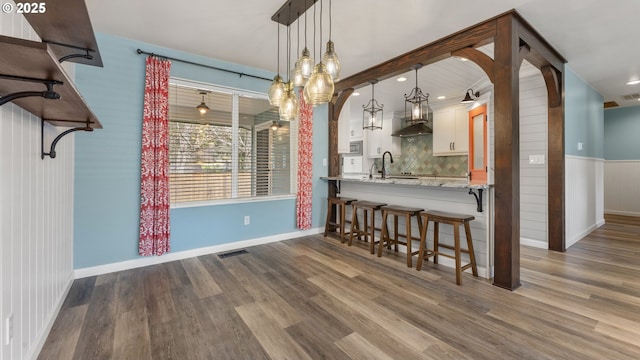 interior space featuring visible vents, baseboards, and wood finished floors