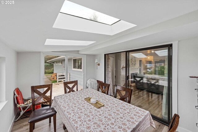 546 W Fir Ave, Coos Bay, OR 97420 - dining area featuring baseboards, a skylight, and light wood-style floors