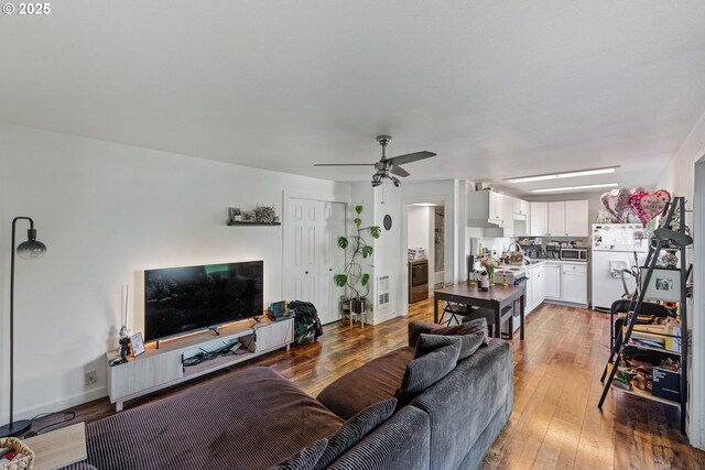 546 W Fir Ave, Coos Bay, OR 97420 - living room featuring light wood-style flooring, baseboards, and ceiling fan