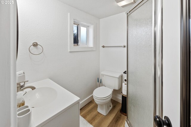 546 W Fir Ave, Coos Bay, OR 97420 - bathroom with vanity, wood finished floors, baseboards, a shower stall, and toilet
