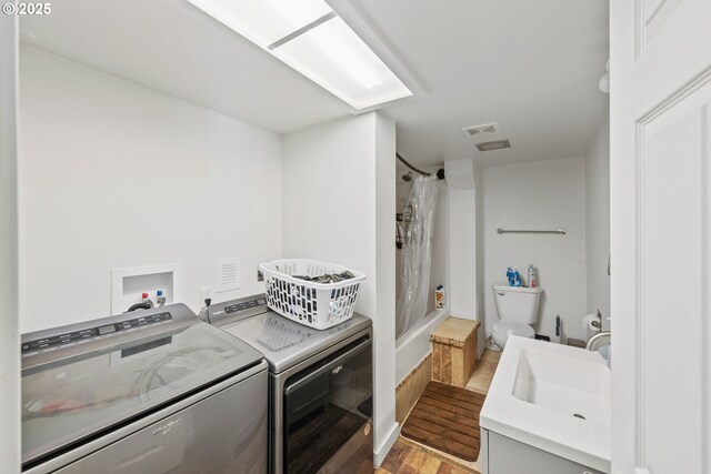 546 W Fir Ave, Coos Bay, OR 97420 - washroom featuring washer and clothes dryer, visible vents, wood finished floors, and a sink
