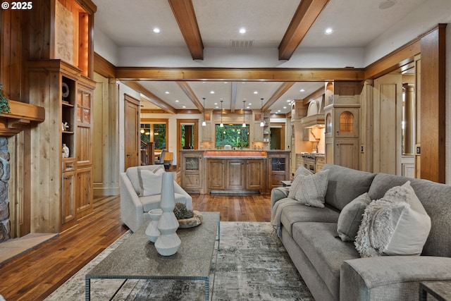 living room with light hardwood / wood-style floors, beamed ceiling, and wood walls