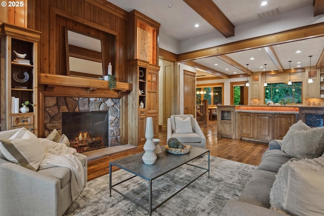 living room with beam ceiling, a fireplace, and light hardwood / wood-style floors