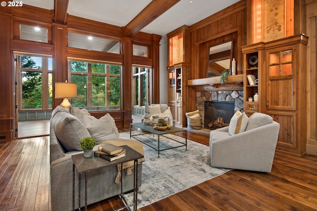 living room featuring a healthy amount of sunlight, dark hardwood / wood-style floors, and beam ceiling