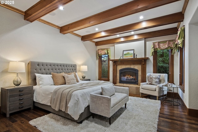 bedroom with a fireplace, dark hardwood / wood-style floors, and beam ceiling