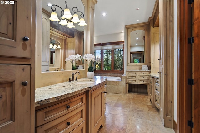 bathroom with vanity, tiled bath, and a notable chandelier