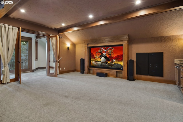 carpeted cinema room with french doors and lofted ceiling with beams