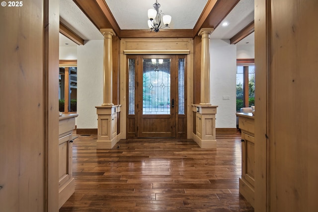 entryway featuring a textured ceiling, decorative columns, dark hardwood / wood-style floors, and a chandelier