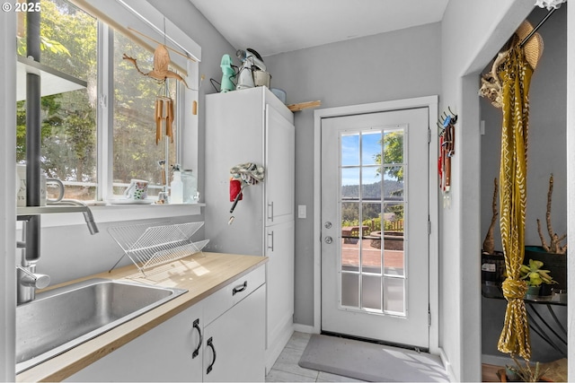 579 S Schooner Creek Rd, Lincoln City, OR 97367 - doorway with a sink, light tile patterned flooring, and baseboards