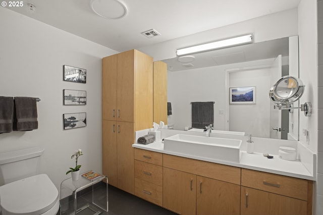 bathroom featuring toilet, vanity, and tile patterned flooring