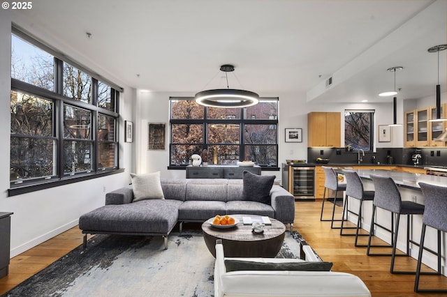 living room featuring wine cooler and light wood-type flooring