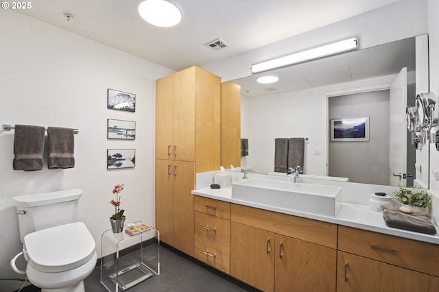 bathroom featuring toilet, vanity, and tile patterned flooring