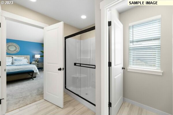 bathroom featuring hardwood / wood-style floors and a shower with door