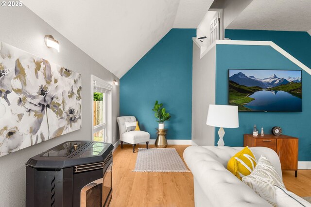 living area featuring wood finished floors, vaulted ceiling, and baseboards