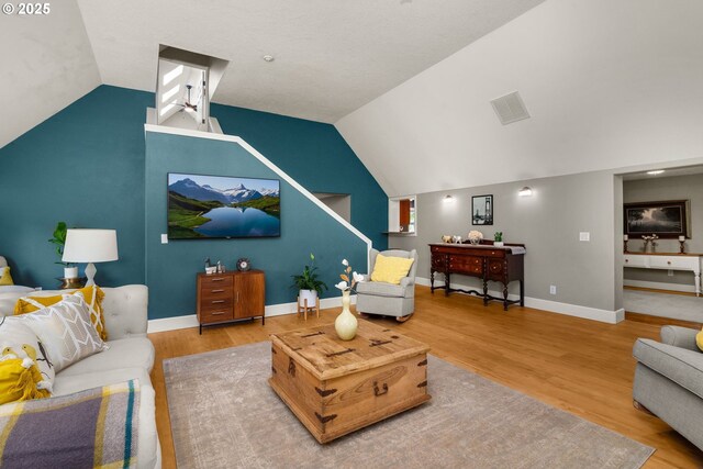 living room featuring vaulted ceiling, wood finished floors, and baseboards